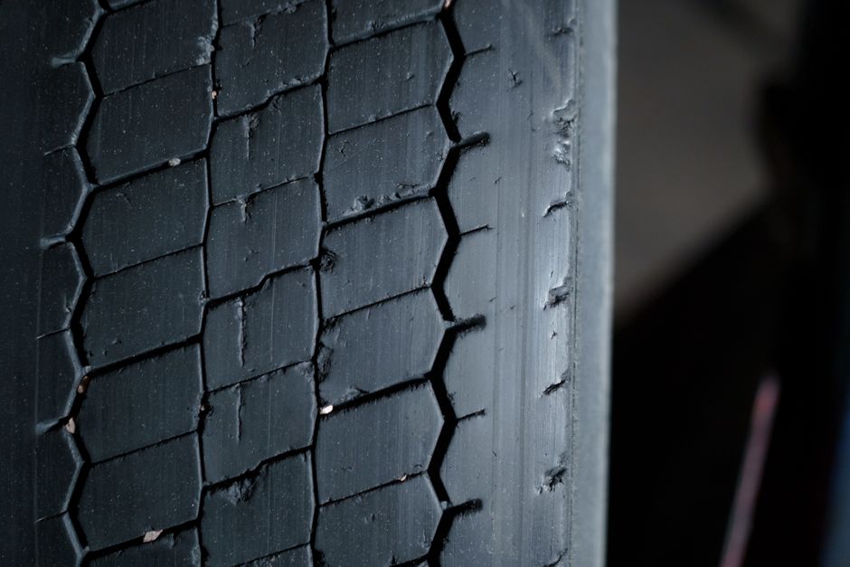 Technician checking tire tread depth and performing alignment checks